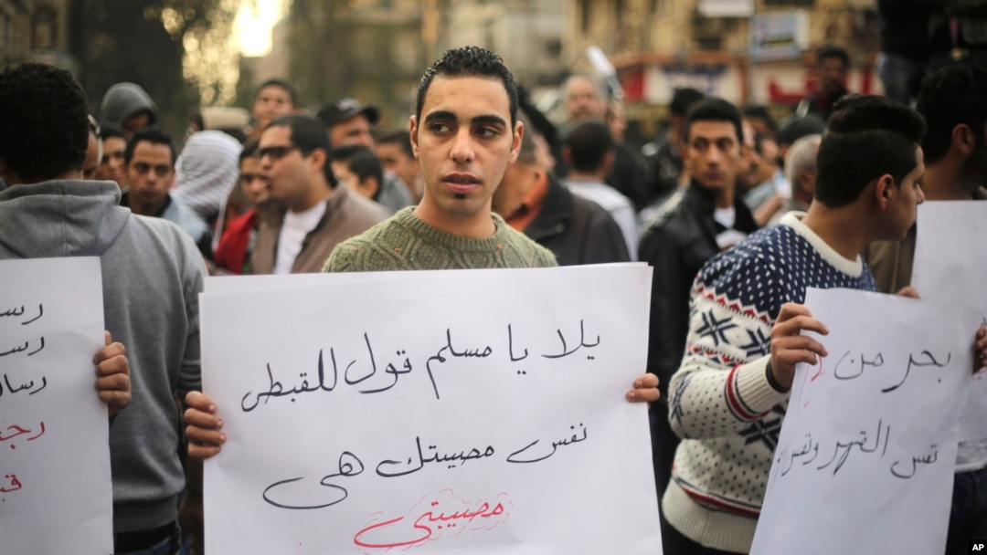 An Egyptian man holds a poster that reads "Muslims and Copts are in the same tragedy" in Arabic, protesting the slaying of Egyptian Coptic Christians in Libya by militants associated with the Islamic State group, in Cairo, Egypt, Feb. 16, 2015.