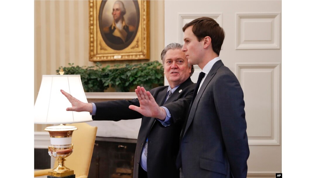 FILE - Steve Bannon, left, talks with White House senior adviser Jared Kushner in the Oval Office of the White House, Feb. 3, 2017.