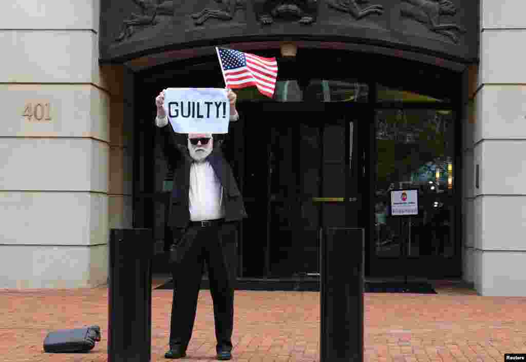 After a guilty verdict on the first count, an unidentified man holds a sign outside the U.S. District Courthouse in Alexandria, Virginia, Aug. 21, 2018, for the fourth day of jury deliberations in former Trump campaign manager Paul Manafort's trial on bank and tax fraud charges.