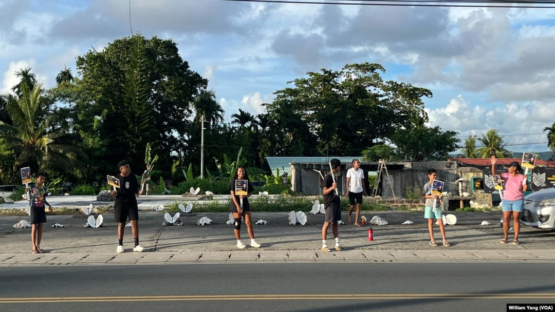 Palauans hold election signs along the streets of Koror ahead of Palau's Nov. 5 general elections.