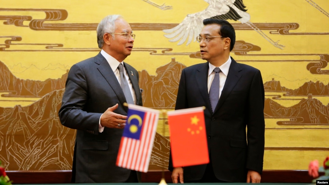 Malaysia's Prime Minister Najib Razak (L) speaks to China's Premier Li Keqiang during a signing ceremony at the Great Hall of the People, in Beijing, May 29, 2014.
