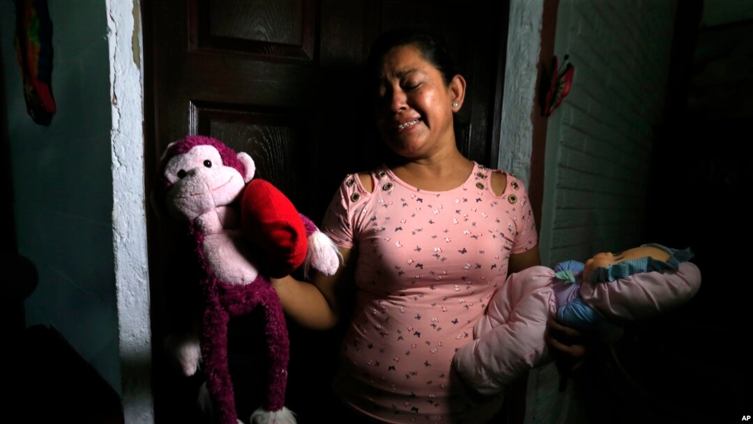 Rosa Ramirez sobs as she shows journalists toys that belonged to her nearly 2-year-old granddaughter Valeria in her home in San Martin, El Salvador, Tuesday, June 25, 2019. 