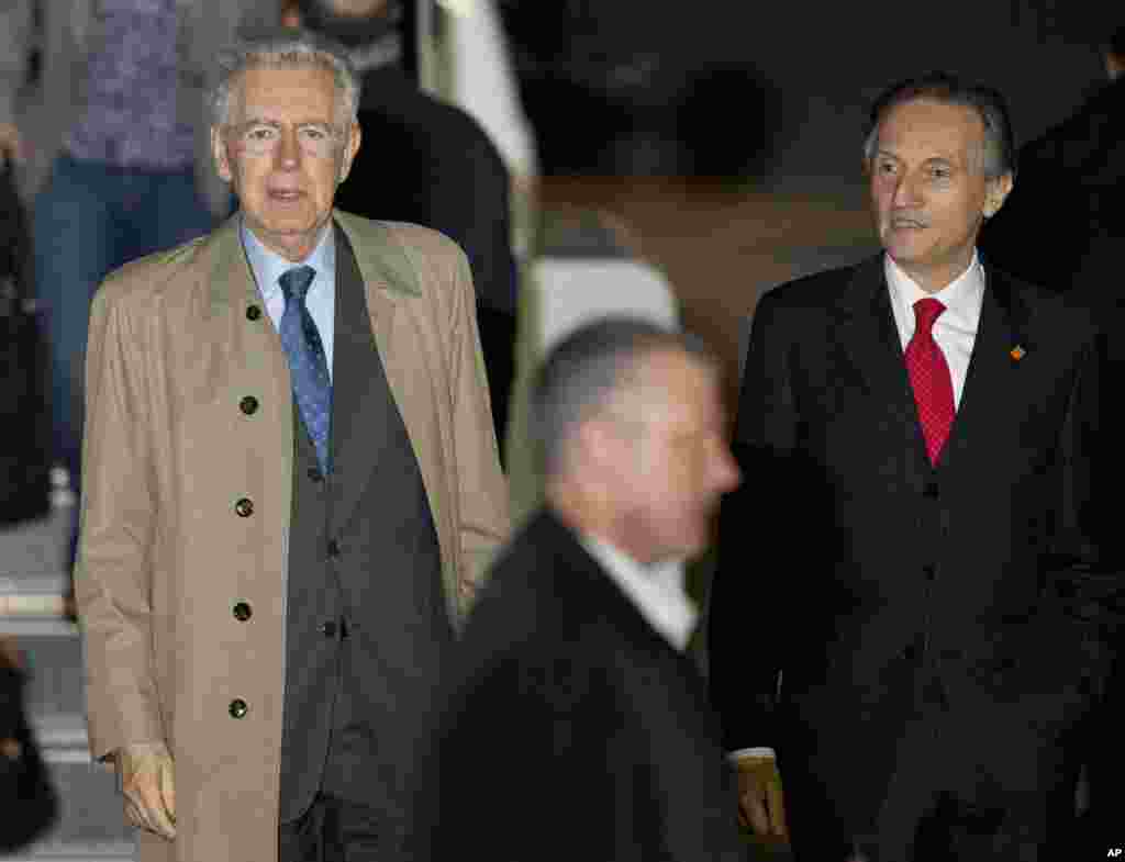Italian Prime Minister Mario Monti, left, walks to a motorcade upon his arrival at Dulles International Airport.