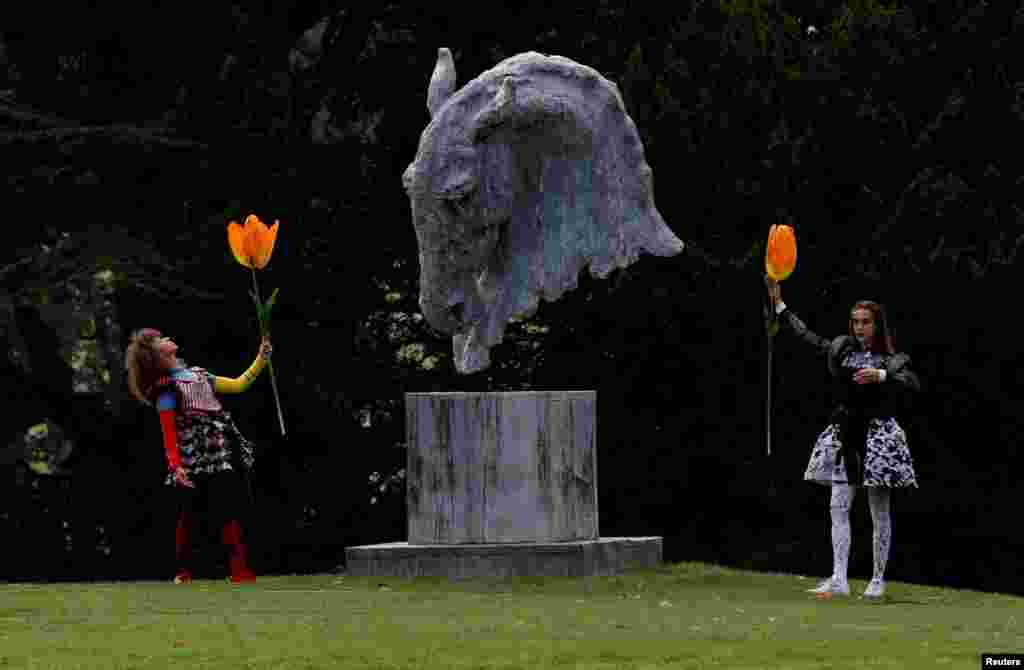 Dancers perform next to a sculpture entitled "Into the Wind" by Nic Fiddian-Green during the Chatsworth Outdoors exhibition at Chatsworth House near Edensor, Britain.