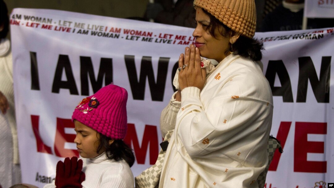An Indian woman and her daughter pray as they take part in a silent protest to mourn the death of a gang rape victim in New Delhi, India, Tuesday, Jan. 1, 2013.
