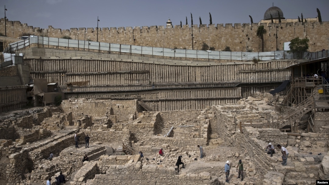 Members of the media and workers from Israel's antiquity authority stand at a site that archaeologists say contains the remnants of an ancient Greek fortress, outside the walled Old City of Jerusalem, Nov. 3, 2015. 