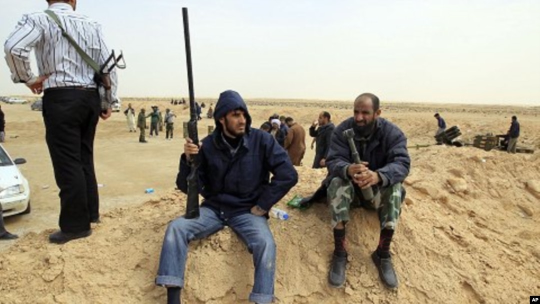 A rebel holds a gun on the outskirts of Ajdabiya, on the road leading to Brega, Libya, March 2, 2011