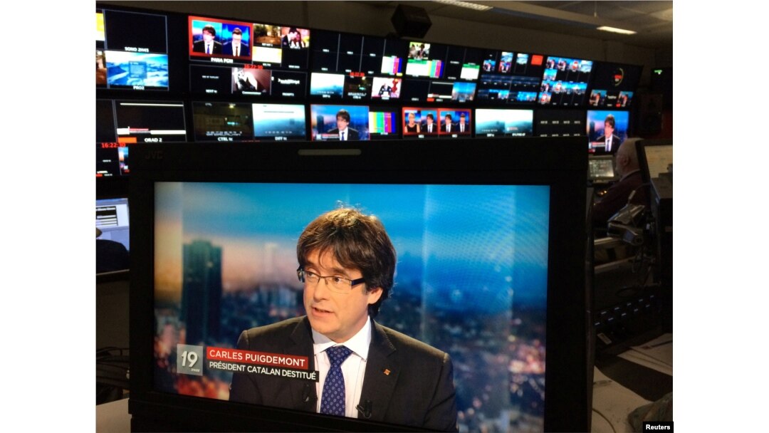 Ousted Catalan President Carles Puigdemont appears on a monitor during a live TV interview on a screen in a bar in Brussels, Belgium, Nov. 3, 2017.