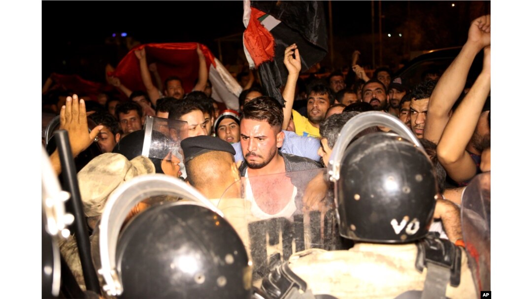 Iraqi riot police prevent protesters from storming the provincial council building during a demonstration in Basra, 340 miles (550 kilometers) southeast of Baghdad, Iraq, early Saturday, May 21, 2016.