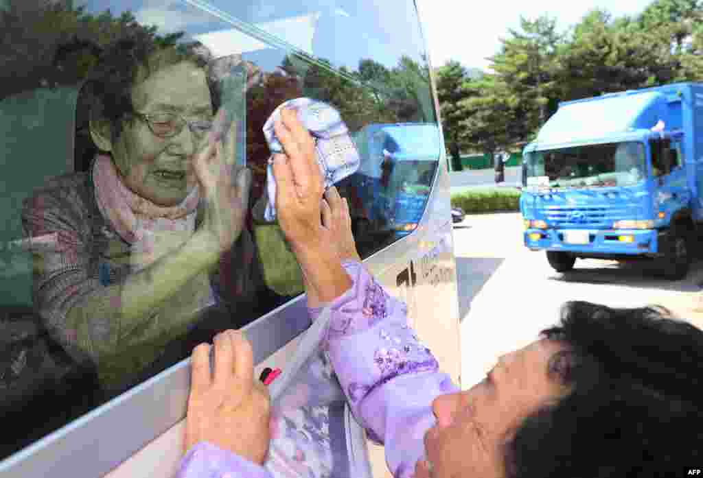 South Koreans (on the bus) bid farewell through the window to their North Korean relatives at the end of a three-day family reunion event at North Korea's Mount Kumgang resort. Elderly North and South Korean family members allowed to meet for the first time in nearly seven decades.