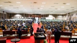 Pan African Parliament members gather in groups inside the house following its postponement in Midrand, Johannesburg on June 1, 2021.