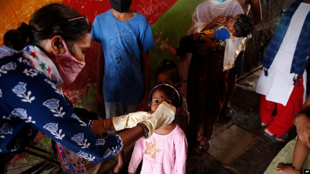 FILE - A health worker administers polio drops to children at a slum in Mumbai, India, June 27, 2021.