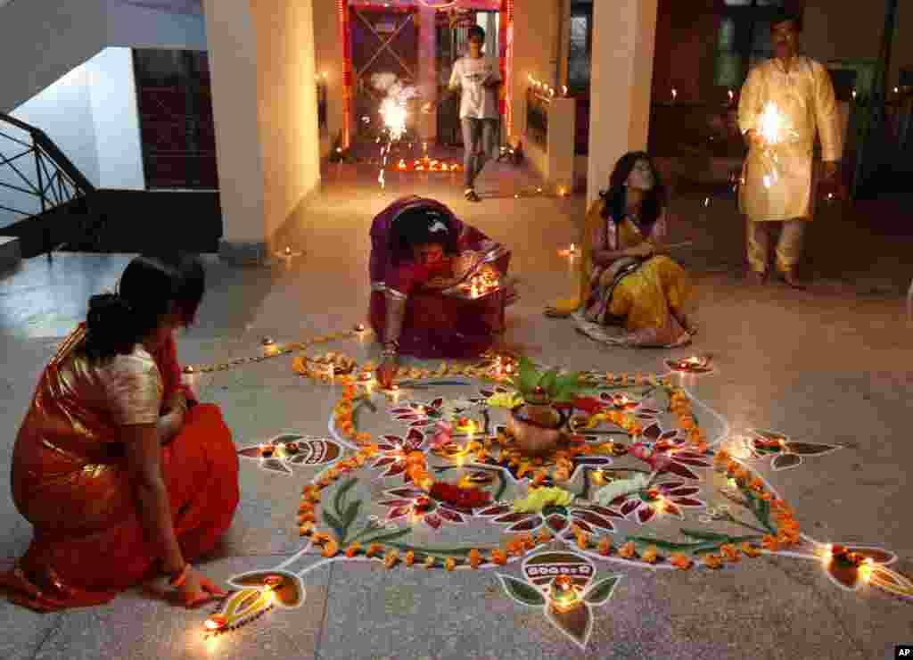 Indian Hindu women light earthen lamps to celebrate Diwali, Allahabad, India, Nov. 3, 2013.