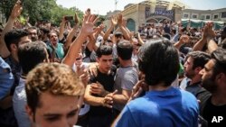 A group of protesters chant slogans at the main gate of the Grand Bazaar in Tehran, Iran, June 25, 2018.