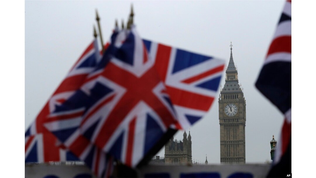 FILE - Union flags displayed on a tourist stall, with the Houses of Parliament and Elizabeth Tower containing the bell know as Big Ben in the background, in London, Feb. 8, 2017.