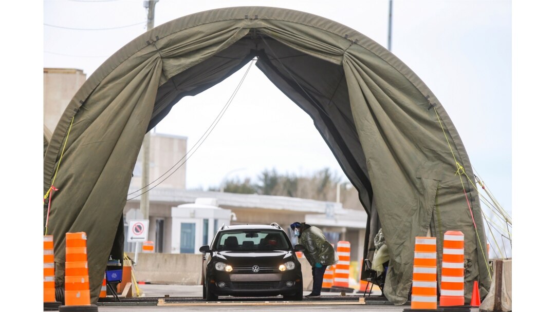 FILE -:Travelers arriving from the United States enter a tent erected to perform the coronavirus molecular test at one of five initial entry points, at the Champlain-St. Bernard de Lacolle Border Crossing in Quebec, Canada, Feb. 24, 2021.