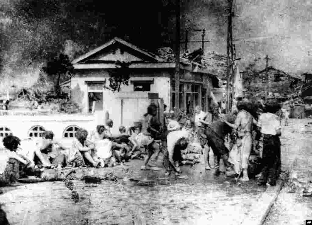 Japanese victims wait to receive first aid in the southern part of Hiroshima, Japan, a few hours after the U.S. atomic bomb exploded in the heart of the city on Aug. 6, 1945. The explosion of the first A-bomb, known as "Little Boy," instantly killed 66,00