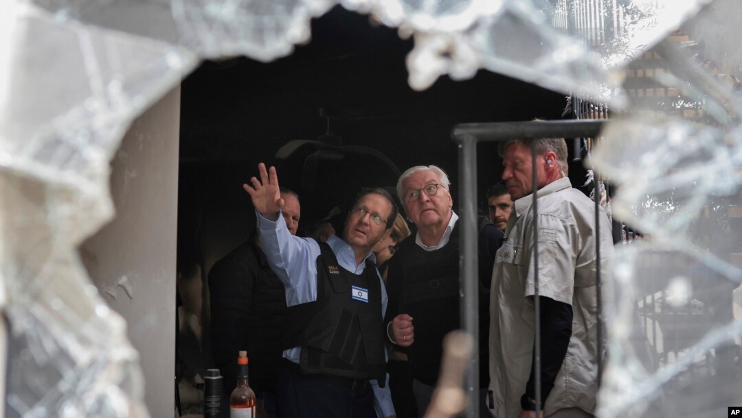 FILE - Israel's President Isaac Herzog, center left, and German President Frank-Walter Steinmeier, center right, visit Kibbutz Beeri in southern Israel, Nov. 27, 2023.
