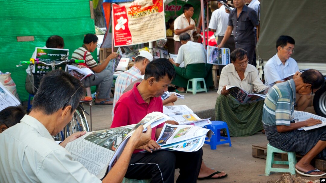 People read local newspapers at a roadside journal shop in Yangon, Myanmar, Nov. 11, 2015.