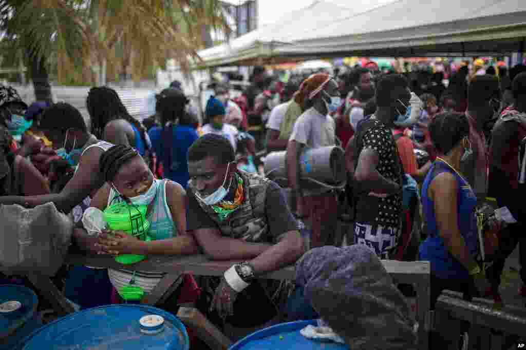 Varios migrantes haitianos se re&#250;nen antes de abordar un bote hacia Capurgan&#225;, cerca de la frontera con Panam&#225;, el mi&#233;rcoles 28 de julio de 2021, en Necocl&#237;, Colombia. (AP Foto/Iv&#225;n Valencia)