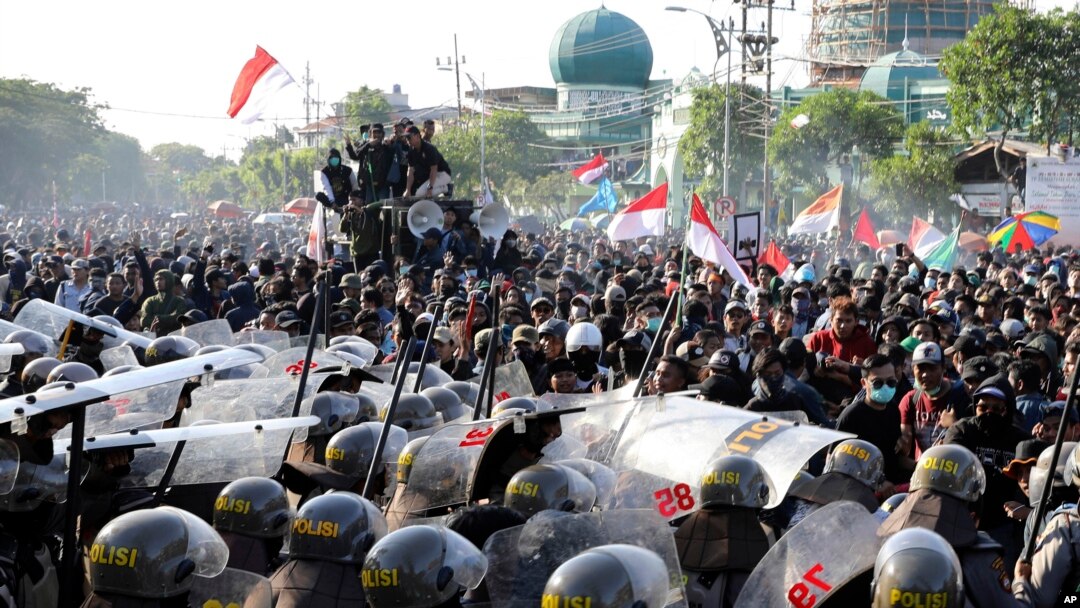 Riot police officers block students from advancing toward the local parliament during a rally in Surabaya, East Java, Indonesia, Sept. 26, 2019. 