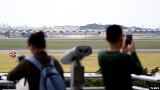 人們在日本南部沖繩島的觀景台遙望嘉手納空軍基地機場。 （2018年3月24日）