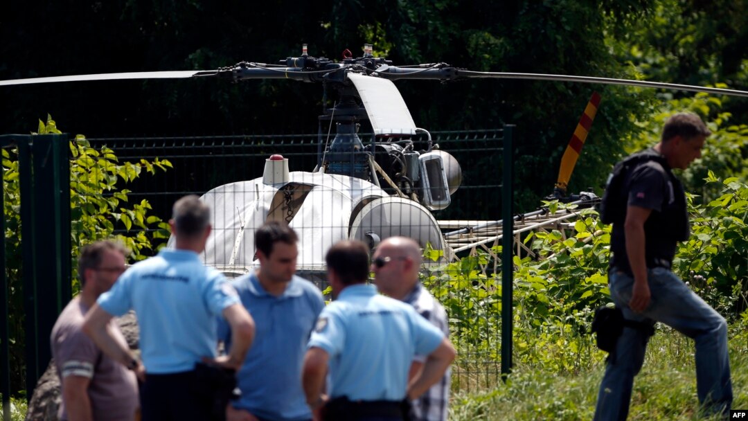 This picture taken July 1, 2018, in Gonesse, north of Paris, shows police near a helicopter abandoned by notorious French gangster Redoine Faid after his escape from prison in Reau, France.