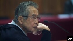 El expresidente de Perú Alberto Fujimori, es fotografiado a través de una ventana de vidrio, mientras asiste a su juicio en una base policial en las afueras de Lima, Perú, el 28 de junio de 2016. Archivo.