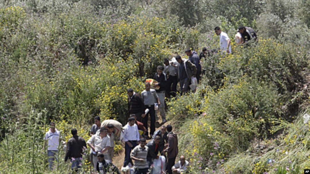 Syrians cross the border into Lebanon as they flee the violence in the Syrian village of Talkalakh, in the Wadi Khaled area, about one kilometer (0.6 miles) from the Lebanon-Syria border, north of Lebanon, May 16, 2011