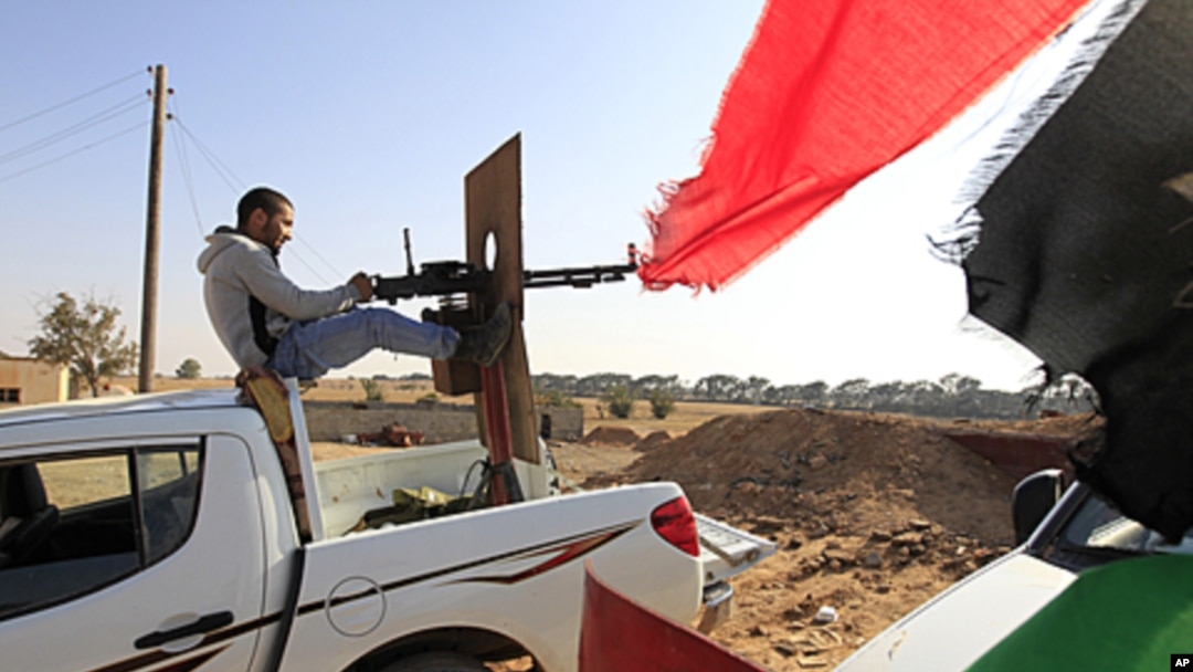 A Libyan rebel fighter aims his heavy machine gun towards forces loyal to Libya's leader Moammar Gadhafi at Misrata's western front line, some 25 kilometers from the city center, May 26, 2011.