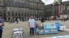 Abdurehim Gheni con fotografías de sus familiares y otros uigures desaparecidos en la plaza Dam de Ámsterdam en julio del 2019.