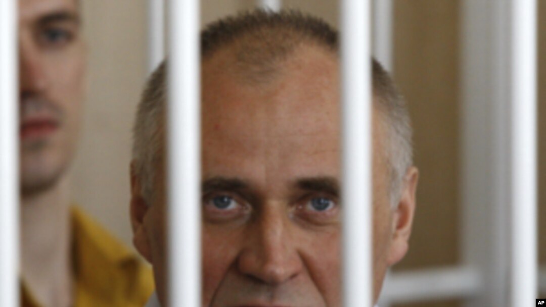 A former opposition presidential candidate Nikolai Statkevich sits in a cage during a court session in Minsk, Belarus, Thursday, May 26, 2011