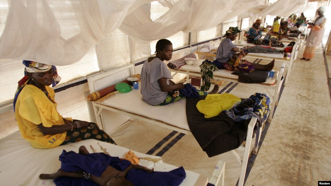 FILE - Women and their babies suffering from malnutrition sit on beds at a make shift hospital in Maradi, Niger, July 30, 2005. 