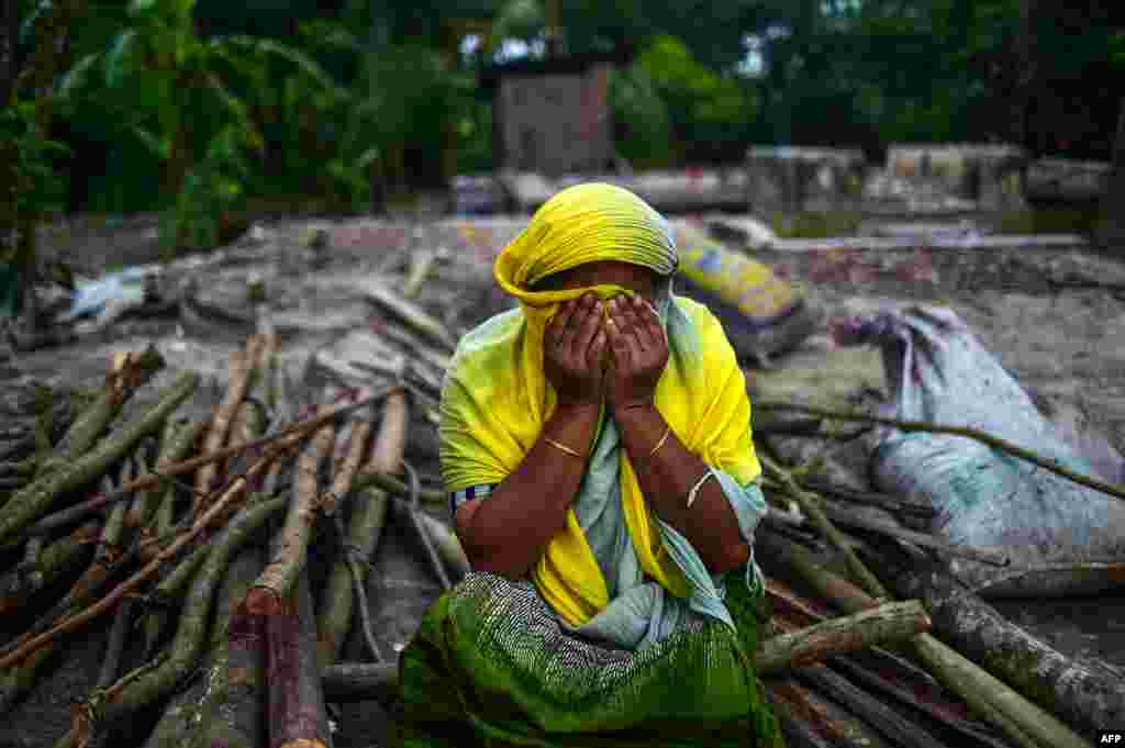 A Bangladeshi woman reacts as she sits next to her destroyed house washed away from the banks of the Padma River at Shariatpur some 40kms south of Dhaka on September 13, 2018, after aggressive erosion of land close to the river in Bangladesh.