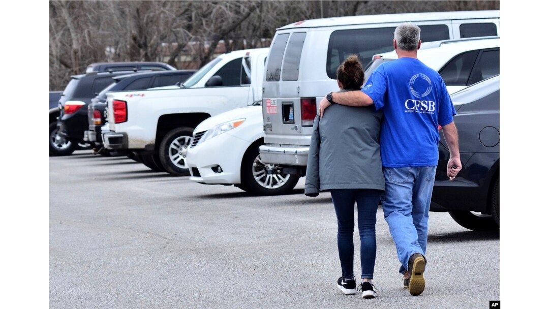 FILE - Family members escort their children out of Marshal North Middle School near Palma, Ky., Jan. 23, 2018, after the students were taken there from Marshal High School.