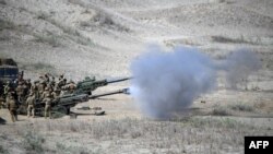 美軍和菲律賓軍隊在聯合演習中，發射M198榴彈炮擊沉假想敵船。（法新社）