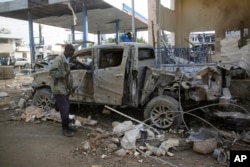 FILE - A Somali security man looks at the wreckage of a truck near the Nasahablood hotel in Mogadishu, Somalia, June 26, 2016. The Islamic extremist group al-Shabab claimed responsibility for the damage, inflicted in an attack the day before.