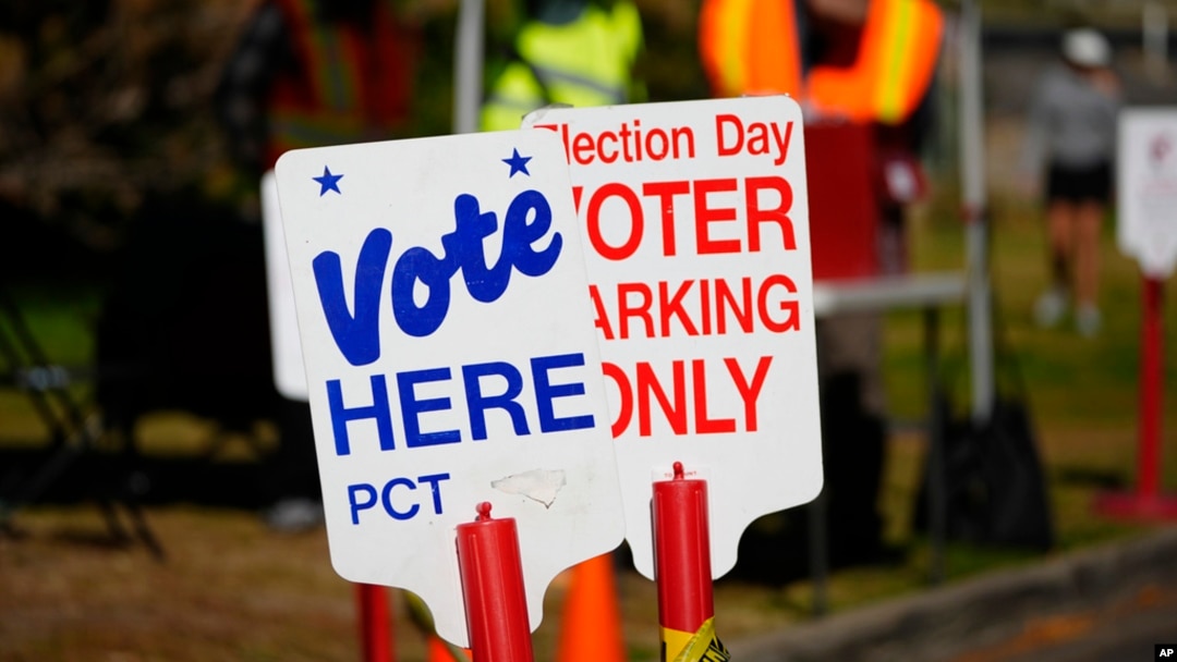 Signs direct voters to a ballot drop-off location, in Washington Park in Denver, Oct. 25, 2024.