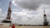 Un trabajador de un campo petrolífero camina junto a las plataformas de perforacion en un pozo de petróleo operado por la petrolera estatal de Venezuela PDVSA. Abril 16, 2015. Foto: Reuters.
