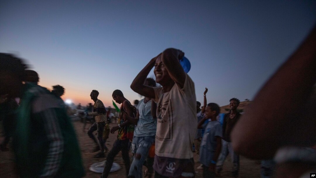 Tigray men who fled the conflict in Ethiopia's Tigray region, run to recieve cooked rice from charity organization Muslim Aid, at Umm Rakouba refugee camp in Qadarif, eastern Sudan, Nov. 27, 2020.