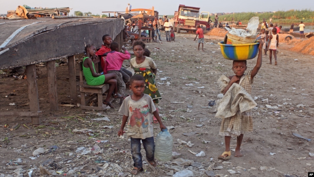 A child (r) carries food stuff on her head that she and other family children try to sell by walking from market area to market area in Kinshasa, Democratic Republic of Congo, May 28, 2014.