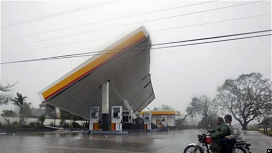 Motorists drive past a filling station which was toppled by typhoon Megi (local name "Juan"), 18 Oct 2010, at Cauayan, Isabela province, northeastern Philippines