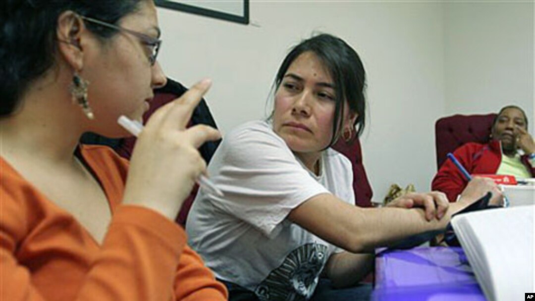 Theresa Rendon (C), originally from Mexico, now living in Queens borough of New York City and working as a housekeeper in New York, listens as Priscilla Gonzalez (L), a Domestic Workers United organizer, translates information from English to Spanish duri