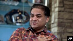 FILE - Ilham Tohti, an outspoken scholar of China's Turkic Uighur ethnic minority, speaks during an interview at his home in Beijing, China.