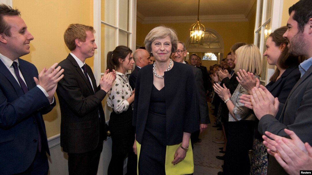 Staff applaud as Britain's new Prime Minister Theresa May, and her husband Philip, walk into 10 Downing Street after May had met Queen Elizabeth in Buckingham Palace, in central London, Britain, July 13, 2016. 