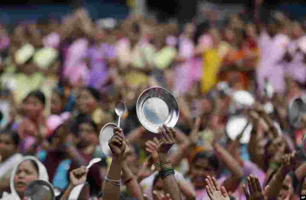 Workers of Anganwadi, or government-sponsored child-care and mother-care, beat plates with spoons and clap their hands during a protest in Mumbai, India.