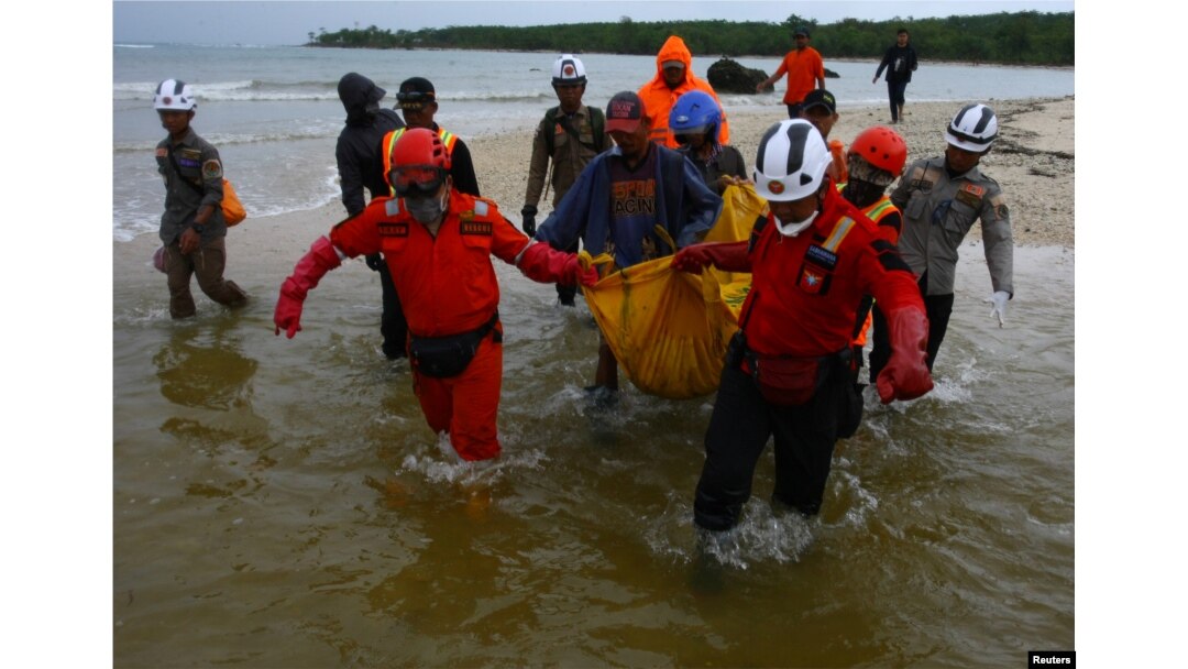 Rescue workers carry a body bag containing the remains of a victim of a tsunami at Tanjung Lesung in Pandeglang, Banten province, Indonesia, Dec. 25, 2018.