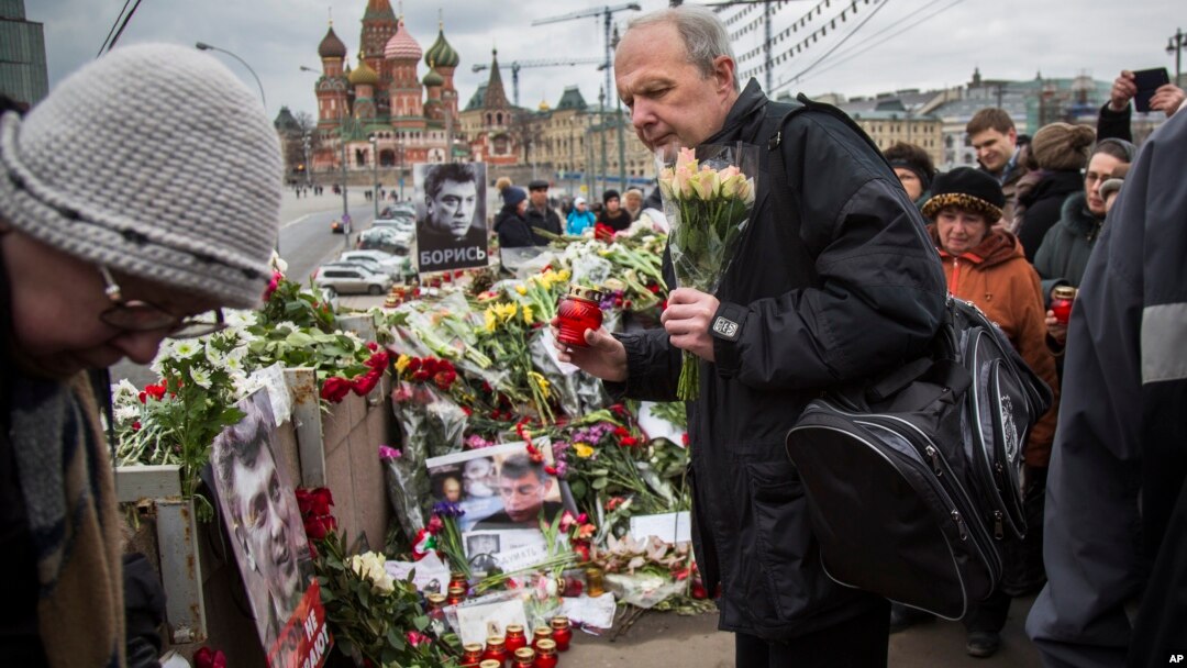 Mourners following the Russian tradition of memorializing a person nine days after a death lay flowers and votive candles at the place where Boris Nemtsov was gunned down near the Kremlin, in Moscow, on Saturday, March 7, 2015. 