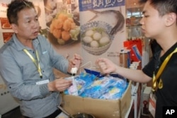 廣州市民歐先生(右)試吃台灣花枝丸