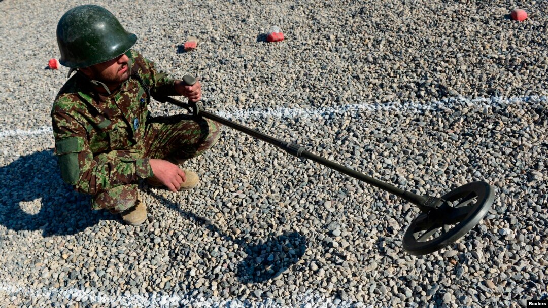 FILE - An Afghan soldier uses a mine detector during a demining drill at Camp Shaheen, a training facility for the Afghan National Army (ANA), west of Mazar-i-Sharif, Dec. 13, 2014. 